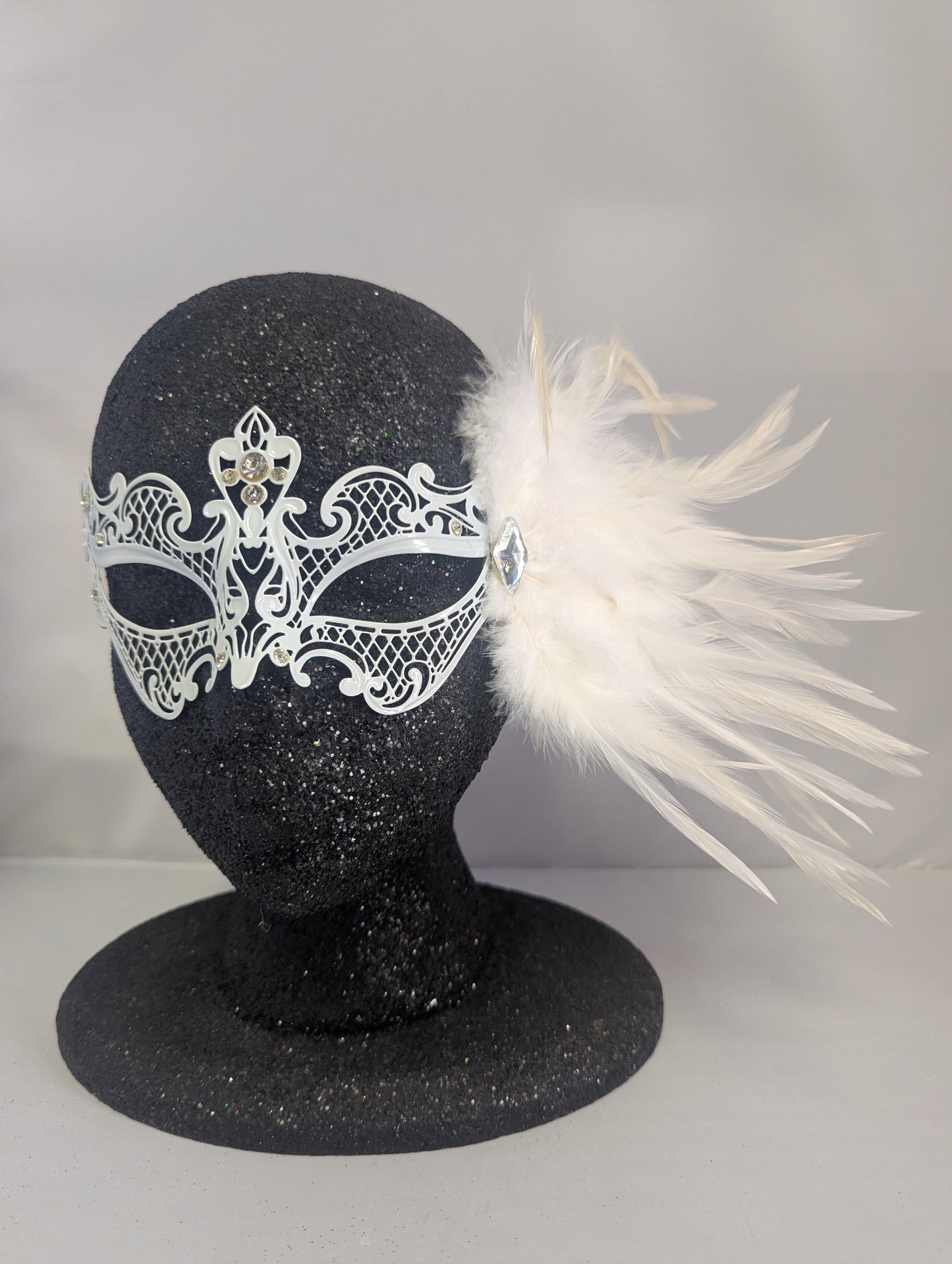 White metal mask with gems and white feathers